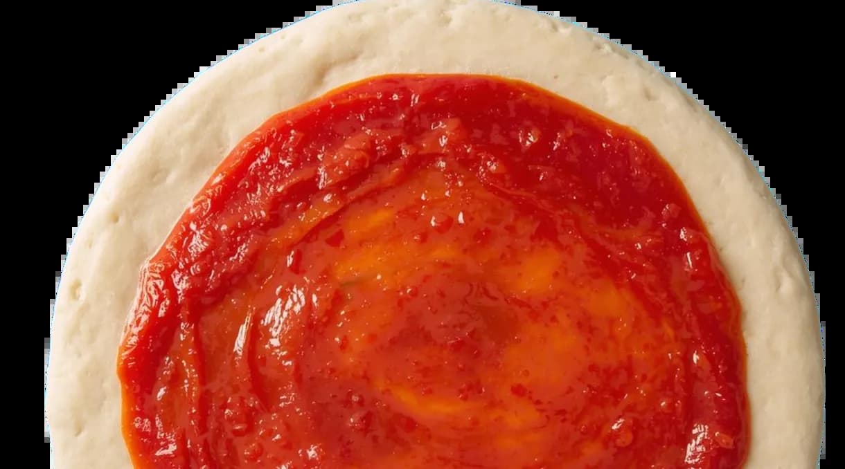 피자 베이스에 토마토 소스를 발린 배경